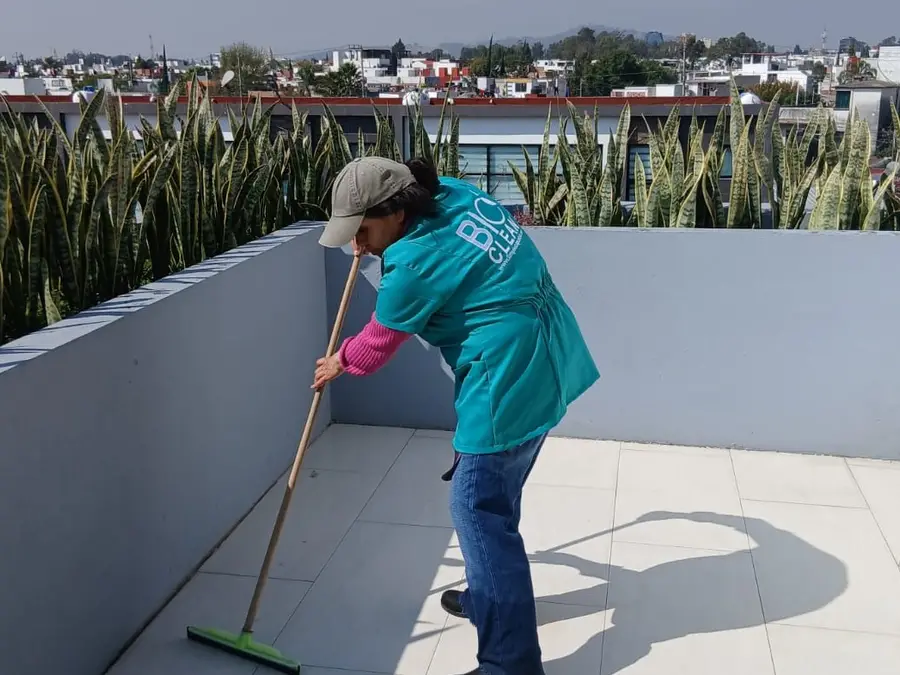 Colaboradora de BioClean barriendo una terraza de áreas comunes en Puebla